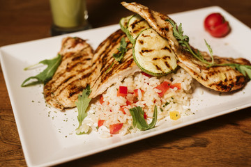 Grilled chicken with rice and vegetables by the glass of juice