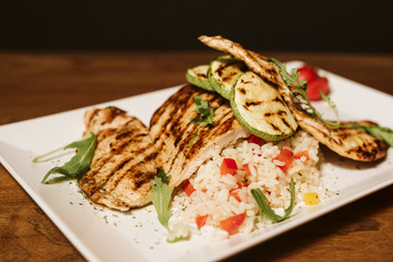 Grilled chicken with rice and vegetables by the glass of juice