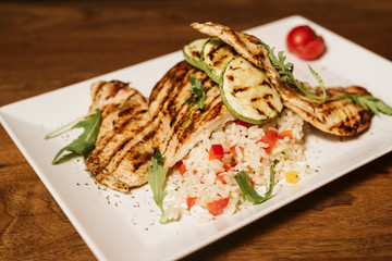 Grilled chicken with rice and vegetables by the glass of juice
