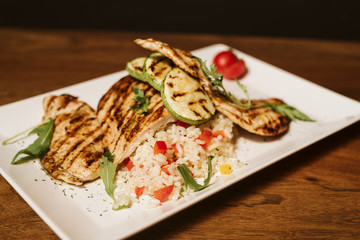 Grilled chicken with rice and vegetables by the glass of juice