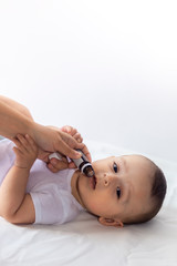 A doctor gives newborn baby rotavirus vaccine. Child immunization with little drop in clinic.Baby...