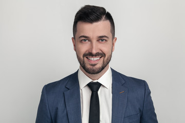 Closeup Portrait of a handsome businessman smiling at the camera. dressed in a suit. Isolated on a white background