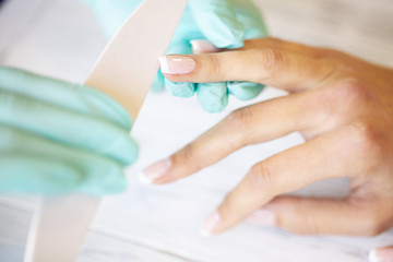 Obraz na płótnie Canvas SPA manicure. French manicure at spa salon. Woman hands in a nail salon receiving a manicure procedure