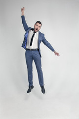 Portrait of a funny and little crazy businessman man jumping and cheering loud isolated on a white background