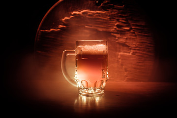 Fototapeta na wymiar Creative concept. Beer glasses on wooden table at dark toned foggy background.