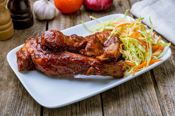 Barbecue pork ribs on white plate with cabbage