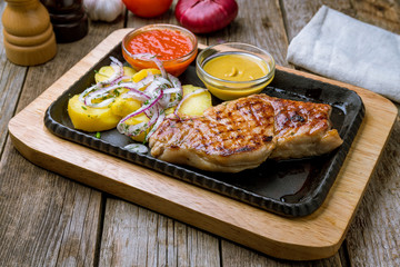 Fried pork loin with sauce on board