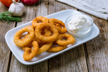 Onion rings in batter on white plate