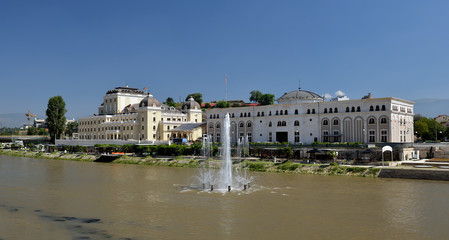 Fototapeta na wymiar Skopje cityscape with the famous Skopje citadel and the Kale fortress reflecting in the water of the Vardar river on a sunny summer day in Macedonia capital city in the Balkans.