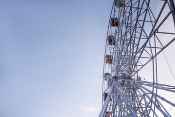 Ferris wheel. Attraction against the blue sky.