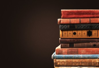 Ancient books in a row on wooden background