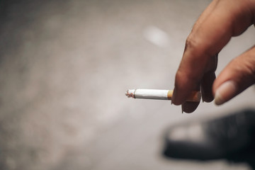 smoking cigarette on back hand with floor background