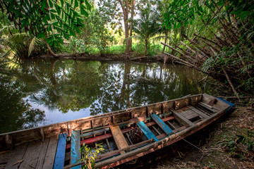 Fototapeta na wymiar The background of the fishing boats that park alongside the river, the atmosphere is surrounded by nature (trees, bamboo groves) with wind blowing all the time