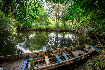 The background of the fishing boats that park alongside the river, the atmosphere is surrounded by nature (trees, bamboo groves) with wind blowing all the time
