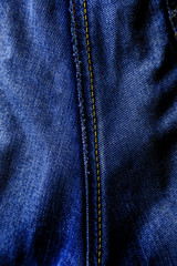 Naklejka premium Beautiful texture of blue denim with a seam in the middle of the frame.