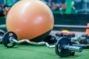 The background of the exercise equipment set for good health (steel balls, dumbbells, cable, weightlifting, boxing boxing gloves, fitness balls) has a blurred light that Fall 