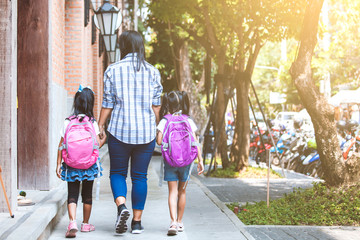 Back to school. Asian mother and daughter pupil girl with backpack holding hand and going to school together