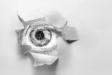 Eye in a hole of torn paper