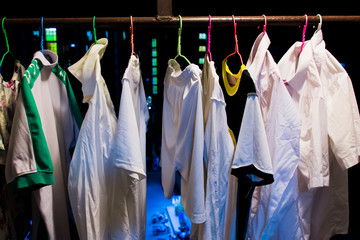 line dry clothes on the rails in the balcony with the background is buildings and roads at night.