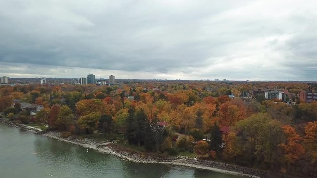 Drone shot of City of Vaughan, Ontario, Skyline from Lake with Autumn Leaves and Park Trees and Overcast Sky
