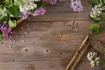 Decor of flowers on the background of vintage wooden planks.Vintage background with lilac flowers and place under the text. View from above. Flat lay. Cutlery.