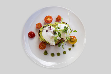 Smashed Avocado and Poached Eggs with cherry tomatoes