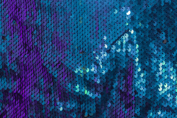 Texture of fabric with round  purple and turquoise sequins. Shiny abstract fashion texture. Similarity of fish scales. © Nataliia