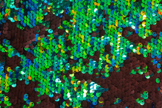 Texture of fabric with round green and black sequins. Shiny abstract fashion texture. Neon trend colors.
