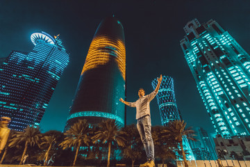 Caucasian man in front of Doha Skysrapers, in Qatar