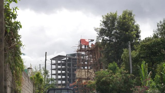 Workers are building a new building using local woods to build scafolding