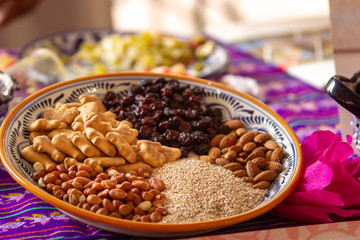 a talavera plate with ingredients to cook mole, cookies, sesame seeds, peanuts, raisins