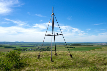 Metal tower on top of a hill. Geodesic, triangulation point. Beautiful, rural landscape.