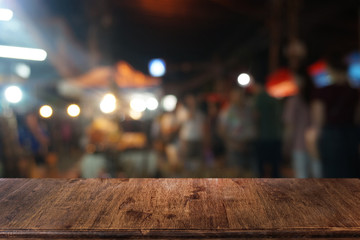 Empty dark wooden table in front of abstract blurred bokeh background of restaurant . can be used for display or montage your products.Mock up for space.