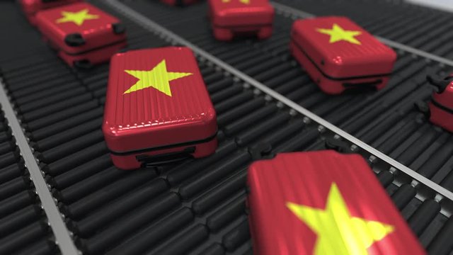 Many travel suitcases featuring flag of Vietnam on roller conveyer. Vietnamese tourism conceptual animation