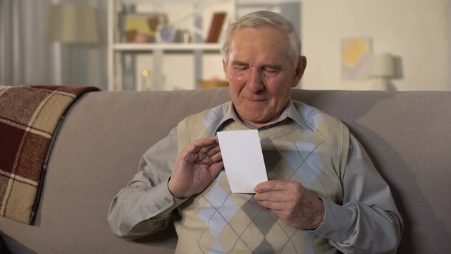 Crying senior widower holding photo, missing wife after funeral, lost family