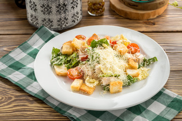 Healthy Grilled Chicken Caesar Salad with parmesan Cheese and Croutons on wooden table