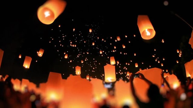 Amazing lanterns of light is released into the night sky by multi ethnic crowd. Celebrate lantern festival of light in Yeepeng festive at Chiangmai, Thailand. Low angle, extreme wide shot. Tilt-Shift.