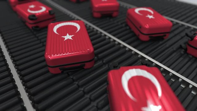 Many travel suitcases featuring flag of Turkey on roller conveyer. Turkish tourism conceptual animation