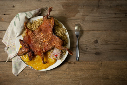 cuy entero frito con papa picante y trigo, comida peruana