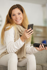 happy woman using mobile phone on sofa