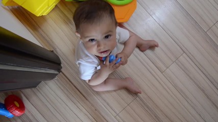 High Angle rotating shot, cute seven months old baby boy playing with educational toys on the floor