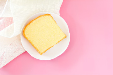 Top view square cut of vanilla butter cake in white dish on pink background with copy space for your text..