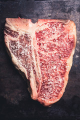 Raw fresh marble T-bone meat on the rustic background. Selective focus. Shallow depth of field.