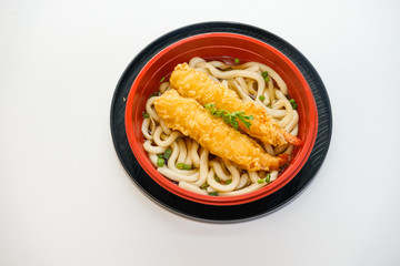 Bowl of udon noodles with fried shrimp isolated on white background