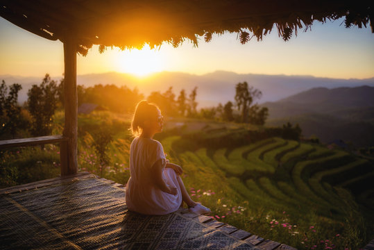 Woman tourism sitting on wood balcony enjoy to Khantok (food tray) Thai food traditionally dinner at Pa Pong Pieng homestay, Mae Chaem, Chiang Mai, Thailand.