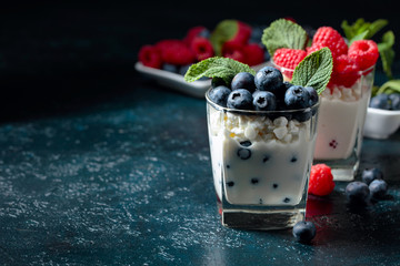 Cottage cheese with cream, raspberry and blueberry garnished with fresh mint.