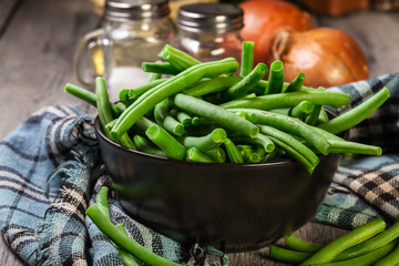 Raw green beans in a black dish