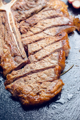 Grilled T-bone steak on the stone board. Selective focus. Shallow depth of field.