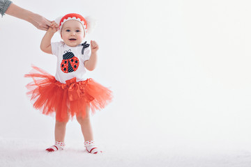 Cute baby learning to walk and make his first steps. mom is holding his hand. child's feet close up, copy space