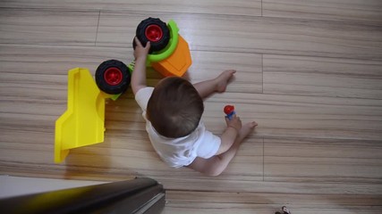 High Angle shot, cute seven months old baby boy playing with educational toys on the floor